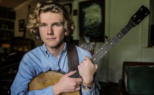 man-with-long-blond-hair-holding-banjo