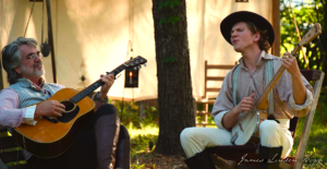 older-and-young-man-playing-music-at-campsite